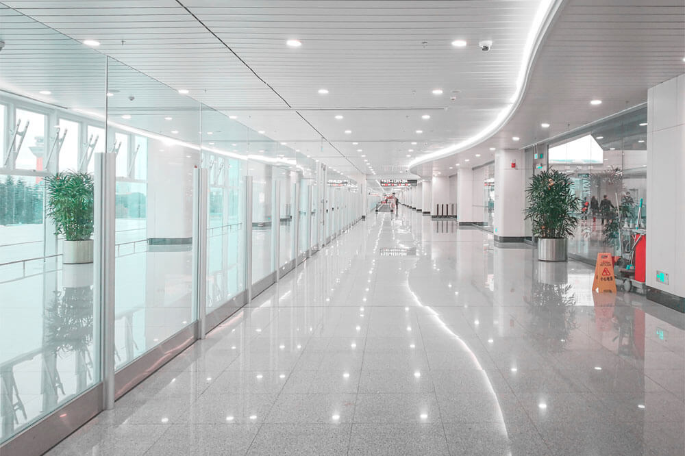 Un largo pasillo en un aeropuerto con paredes de cristal.